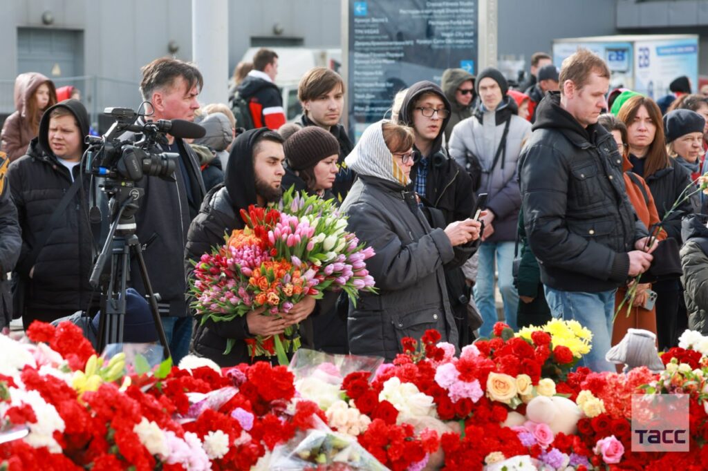Россияне несут цветы к месту убийства людей